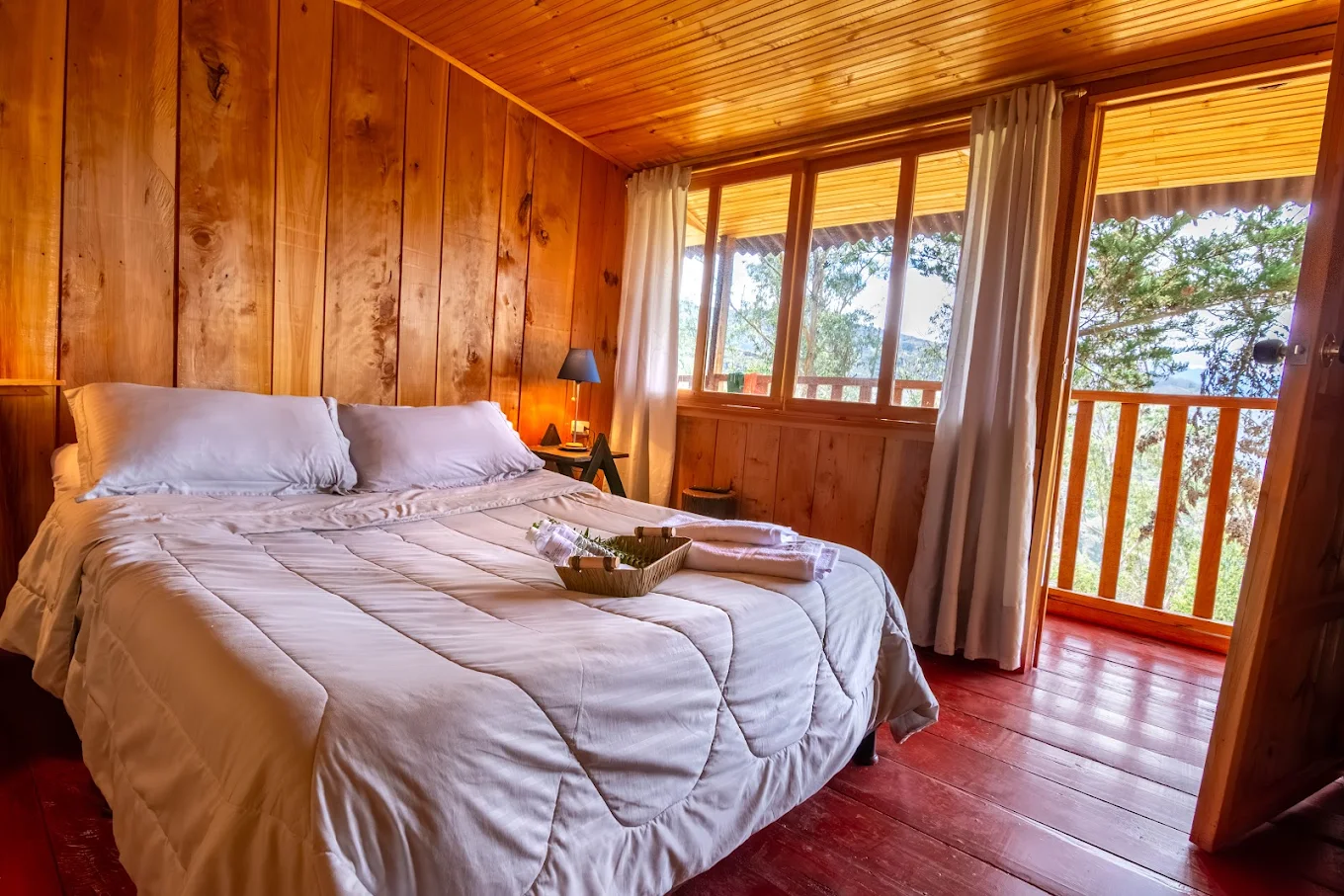 Habitación privada en Casa del Colibrí · cama king en cabaña de madera con vista al jardín