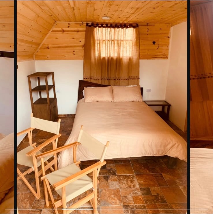 Interior de la cabaña · cama king, paredes de madera y luz cálida